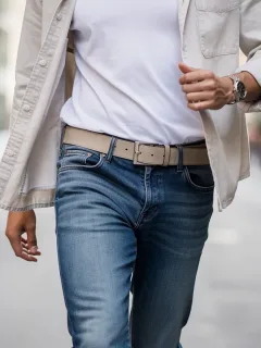 Stylish person accessorizing casual outfit with a modern leather belt for 2026 fashion trends