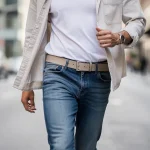 Stylish person accessorizing casual outfit with a modern leather belt for 2026 fashion trends