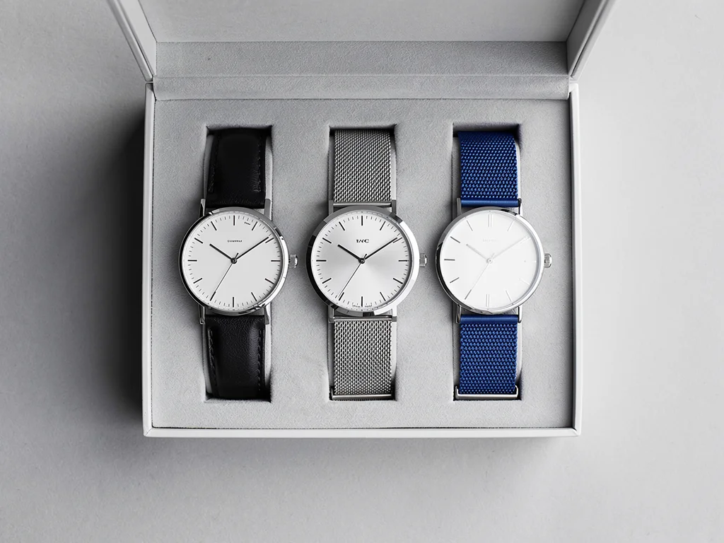 Three minimalist watches in a watch box, diverse styles